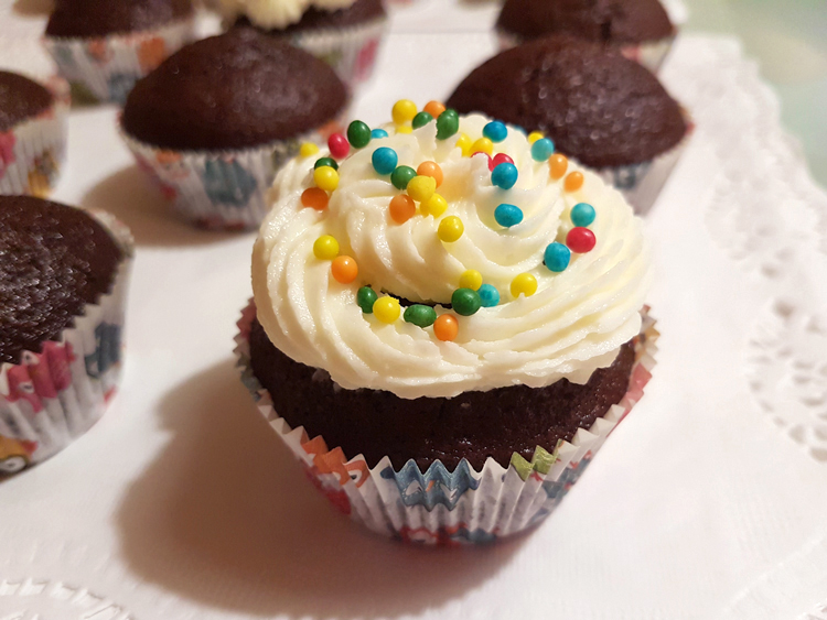 Chocolate cupcake decorated with buttercream frosting and sprinkles