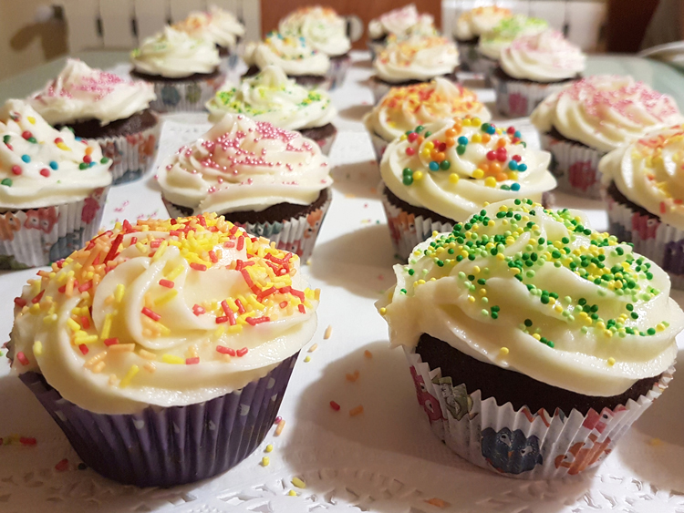 Chocolate cupcakes decorated with buttercream frosting and different color sprinkles